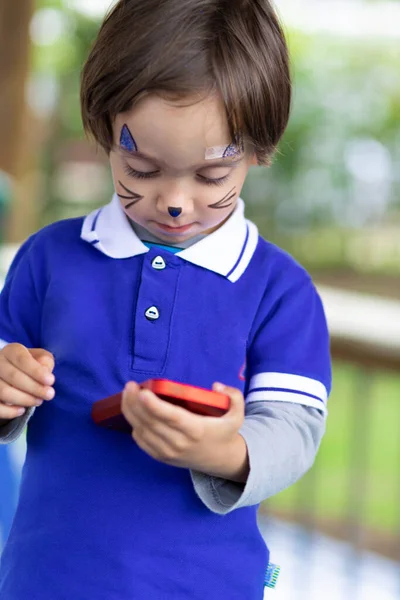 Härlig Pojke Med Målat Ansikte Spela Mobiltelefon — Stockfoto