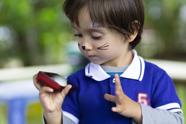 Schöner Junge Mit Geschminktem Gesicht Der Mit Dem Handy Spielt — Stockfoto