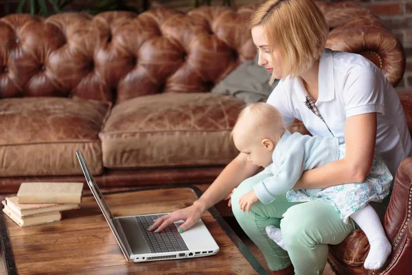 Joven madre trabajando en casa con la niña — Foto de Stock