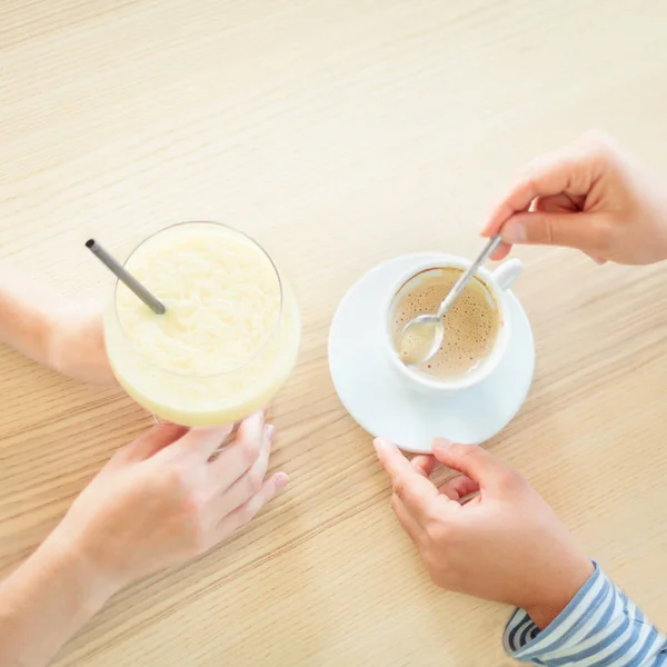 Top view of femake hands with beverages on wooden table — Stock Photo, Image