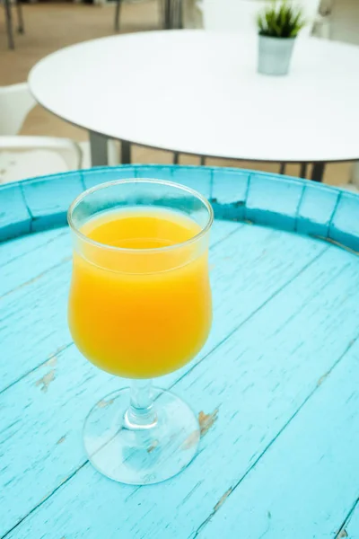 Стакан апельсинового сока на столе в уличном кафе — стоковое фото