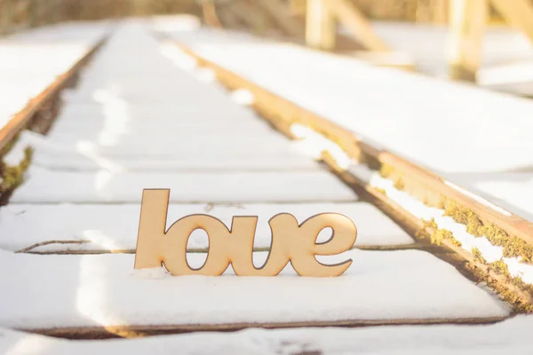 Segno di amore in legno su vecchie rotaie nella neve — Foto Stock