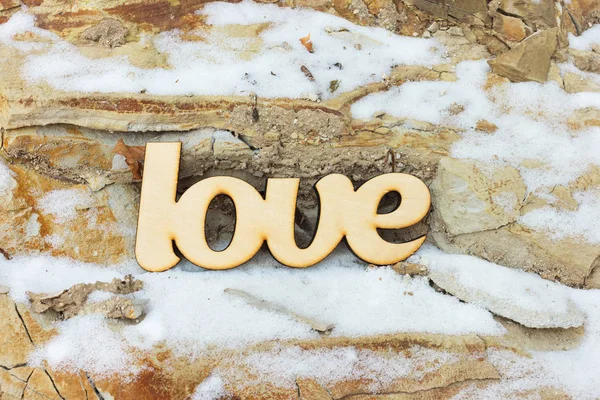 Sinal de amor de madeira na textura de pedra com neve — Fotografia de Stock