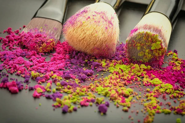 Primer plano de los pinceles de maquillaje con polvo de colores —  Fotos de Stock