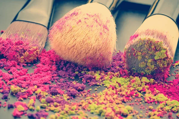 Close-up of make-up brushes with colorful powder — Stock Photo, Image