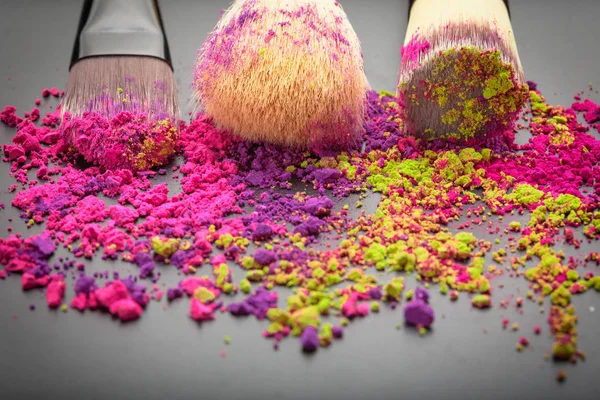 Close-up of make-up brushes with colorful powder — Stock Photo, Image