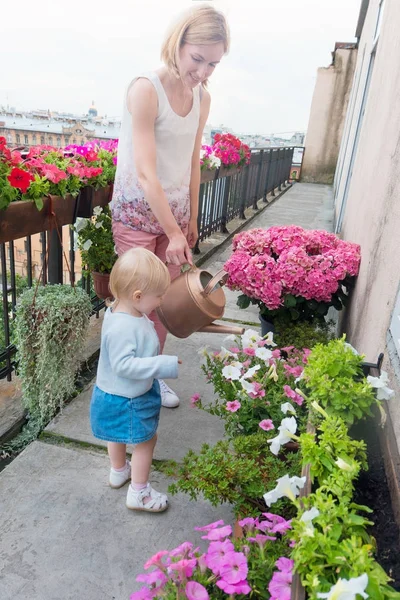 Matka z Córka, podlewania kwiatów na balkon — Zdjęcie stockowe