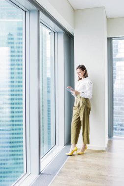 Touchpad üzerinde duran pencere tarafından boş ofisinde çalışan genç kadın