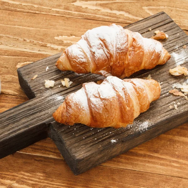 Croissants en tabla de cortar de madera — Foto de Stock
