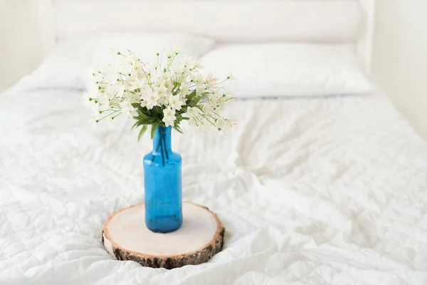 Mavi cam şişe içinde beyaz çiçekler — Stok fotoğraf