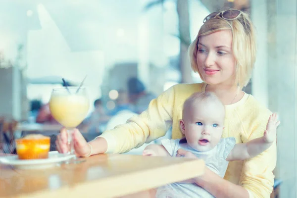 Sonriente madre con el bebé en la cafetería — Foto de Stock