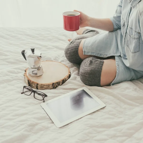 Vrouw met koffie zittend op bed — Stockfoto