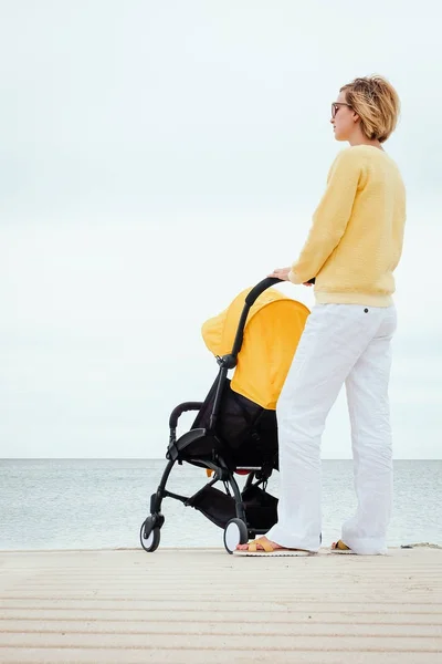 Moeder op een wandeling met kinderwagen — Stockfoto