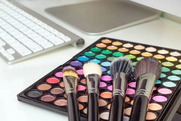 Makeup brushes on colorful makeup palette — Stock Photo, Image