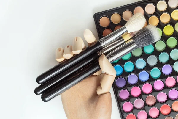 Mannequin hand with makeup brushes and palette — Stock Photo, Image