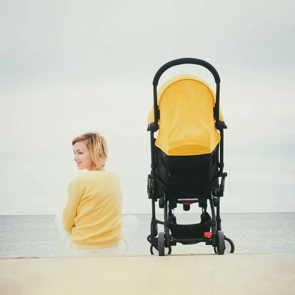 Mãe em uma caminhada com carrinho de criança — Fotografia de Stock