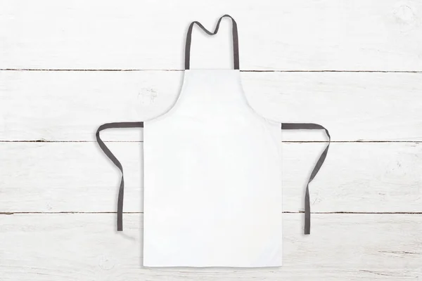 Blank white apron on wooden background — Stock Photo, Image