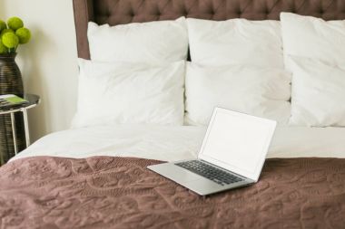 Yastık yatak üstünde laptop