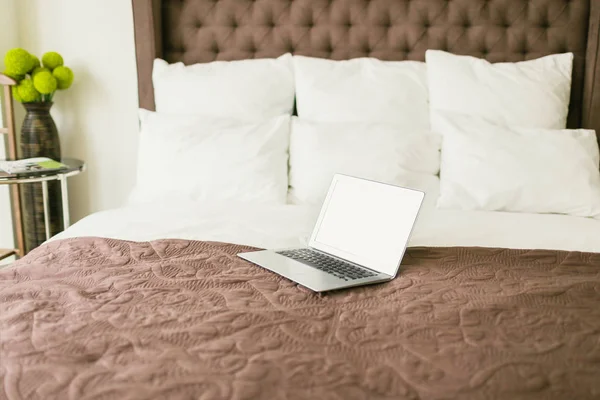 Laptop on bed with pillows — Stock Photo, Image