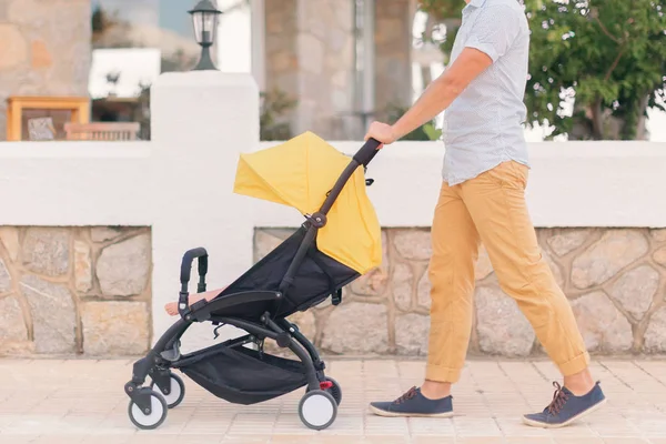 Far promenerande sittvagn med en baby — Stockfoto