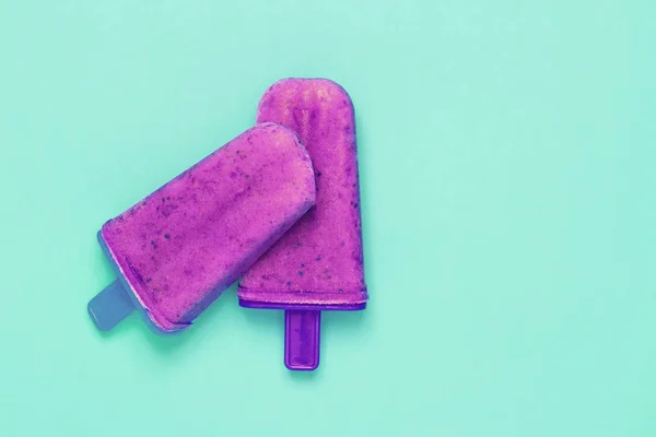 Picolés de sorvete de mirtilo em fundo verde pastel — Fotografia de Stock
