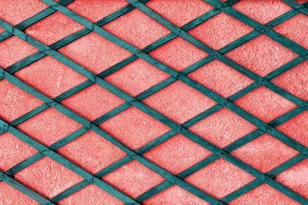 Abstract coral color wall with green wooden planks as a rhombus pattern — Stock Photo, Image