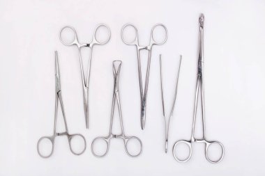 Beyaz arka planda cerrahi aletler. Düz yatıyordu