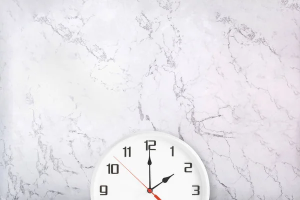 Bílé nástěnné hodiny na přírodním mramoru pozadí — Stock fotografie