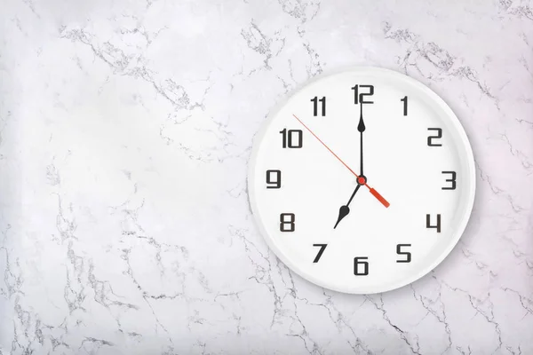 Reloj de pared redondo blanco sobre fondo de mármol natural blanco. Siete relojes — Foto de Stock