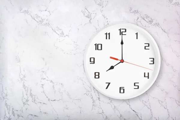 Vit rund vägg klocka på vit naturlig marmor bakgrund. Åtta oclock — Stockfoto