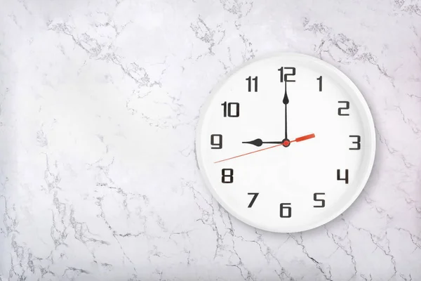 Vit rund vägg klocka på vit naturlig marmor bakgrund. Nio oclock — Stockfoto