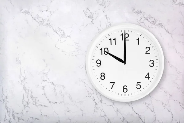 White round wall clock on white marble background — Stock Photo, Image