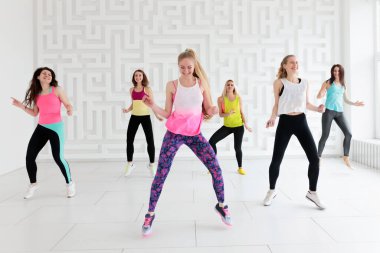 Group of young women in sportswear at dance fitness class