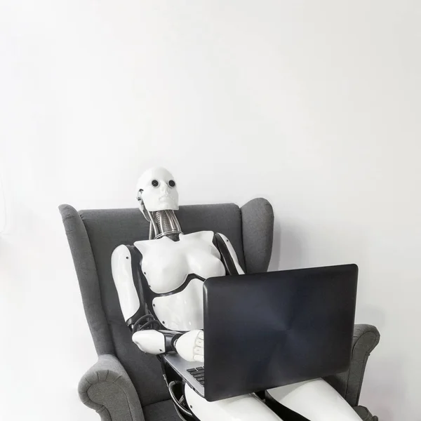 Robot working with laptop while sitting in armchair — Stok fotoğraf