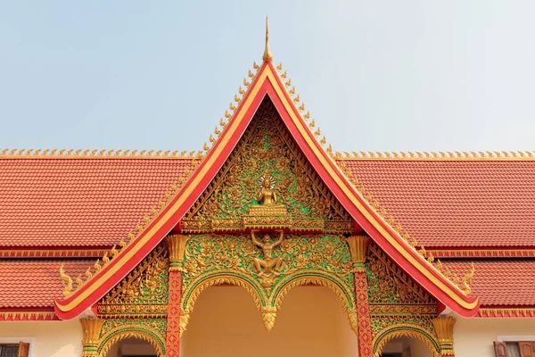 Fragment czerwonego dachu świątyni buddyjskiej z ozdobną złotą dekoracją w Vientiane w Laosie — Zdjęcie stockowe