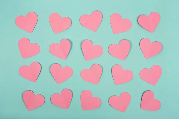 Flat lay of pink paper heart cards on blue background — Zdjęcie stockowe