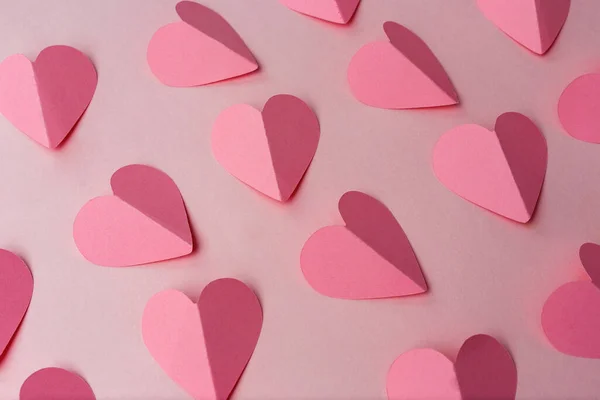 Pink paper hearts on pink background — Stock Photo, Image