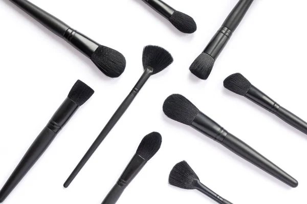 Flat lay of black makeup brushes collection isolated on white background — Stock Photo, Image