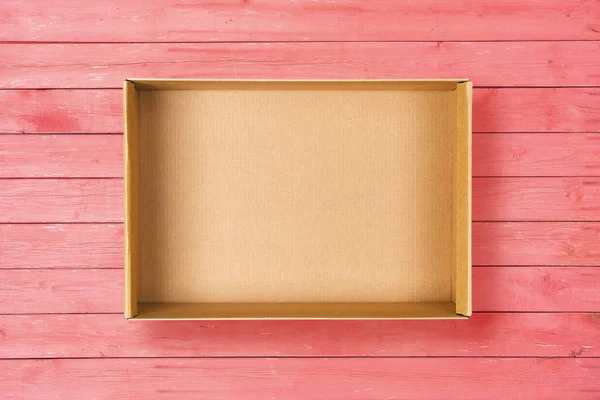 Offene Pappschachtel auf rosa Hintergrund. Leere Pappverpackung auf rosa Holzstruktur — Stockfoto