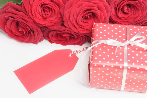 Etiket, hediye kutusu ve güller beyaz üzerine — Stok fotoğraf