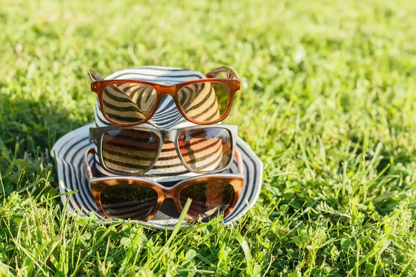 Sombrero femenino a rayas con varias gafas de sol —  Fotos de Stock
