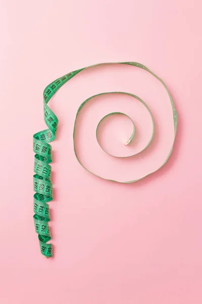 Cinta métrica de sastre espiral sobre fondo rosa — Foto de Stock