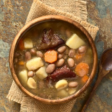 Geleneksel Macar Babgulyas (fasulye gulaş), bir çorba pinto fasulye yapılan, füme et, patates, havuç, csipetke (ev yapımı çorba makarna), sarımsak, soğan, ek yükü barut doğal ışık ile fotoğraflandı ahşap kase hizmet