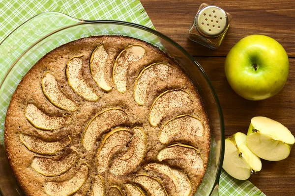Homemade apple and cinnamon cake in glass dish, photographed overhead with natural light