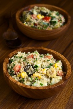 Quinoa salata tatlı mısır, zeytin, domates, salatalık ve ahşap kase, koyu renk ahşap doğal ışık (seçici odak, odak ortasında salata ile fotoğraflandı chives ile)