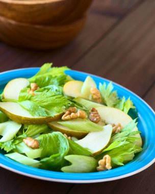 Taze kereviz, armut ve cevizli salata doğal ışık (seçici odak, odak ortasında salata ile fotoğraflandı mavi plaka üzerinde)