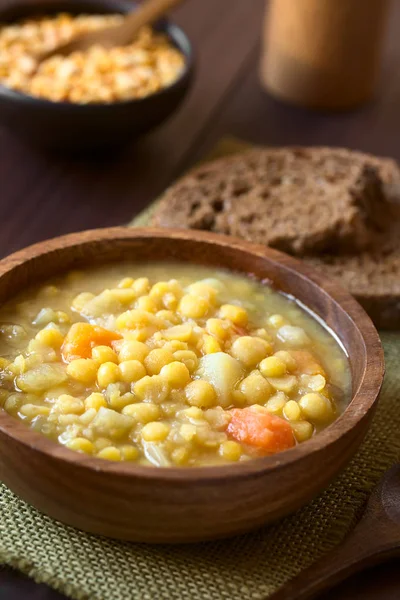 素食主义者和素食主义者黄色豌豆汤或炖土豆 胡萝卜和芹菜在木碗 拍照与自然光 选择性 聚焦在汤 — 图库照片