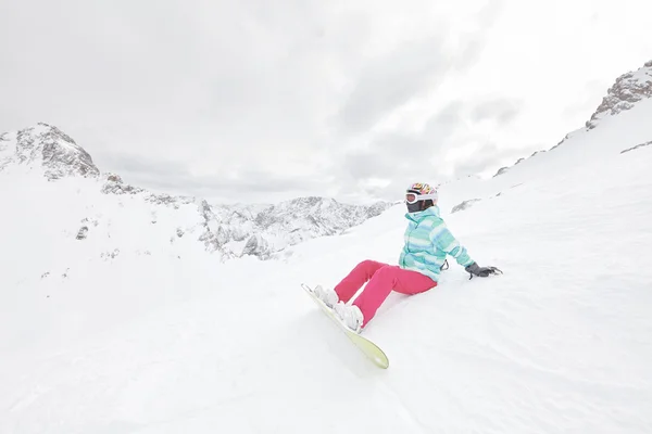 Giovane seduta donna con snowboard — Foto Stock