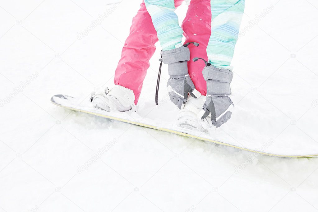 Snowboarder adjusting bindings