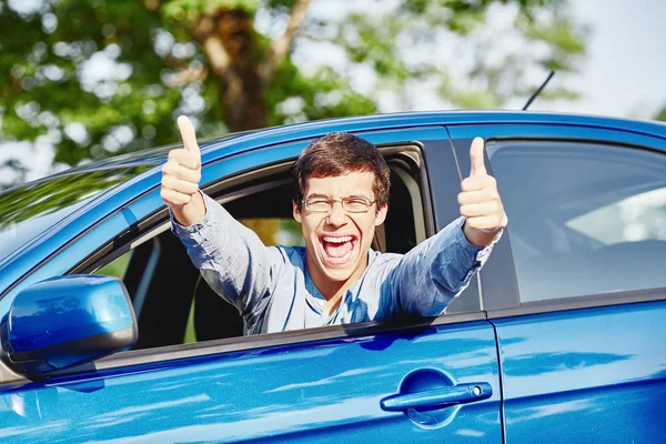 Guy à l'intérieur de la voiture montrant pouces vers le haut — Photo